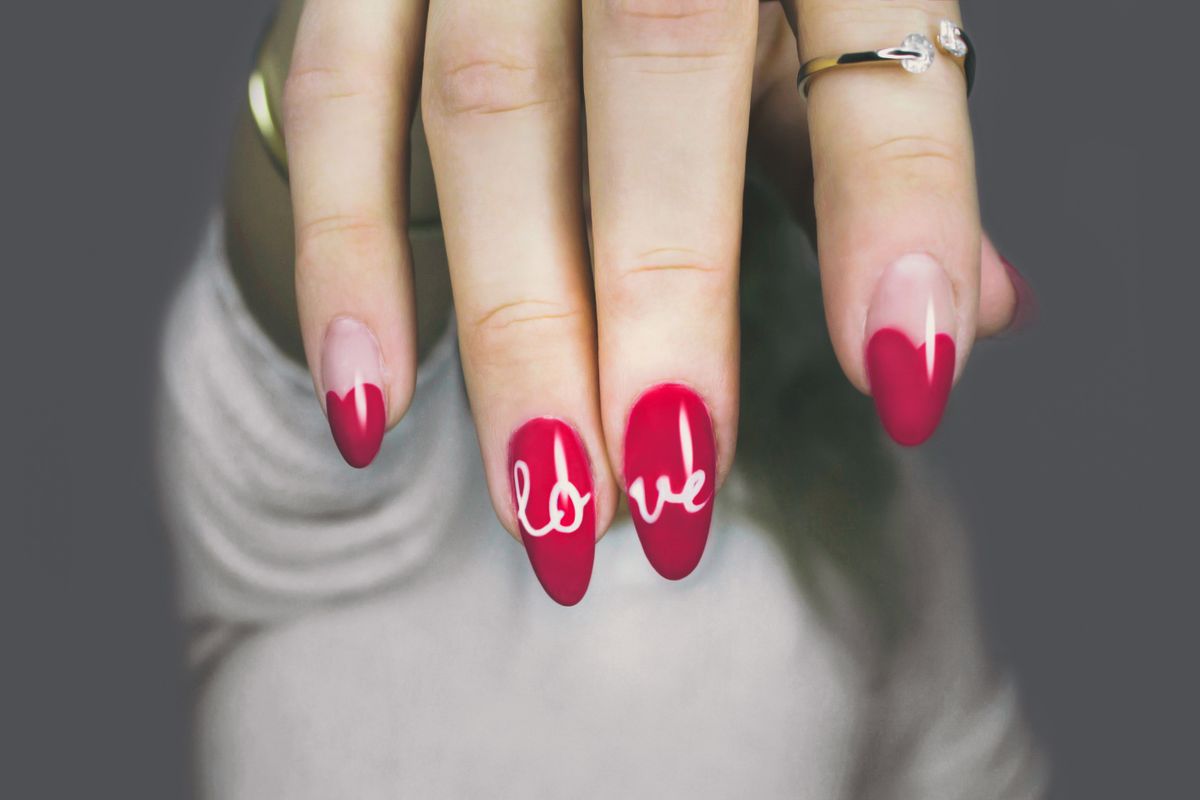 Red nail art manicure with hand-painted lettering